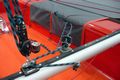 Use the loose end of the very long main sheet to operate the traveller.  This way the helm need only hold one rope.