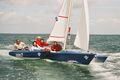 Blue boat, reefed main sail.
